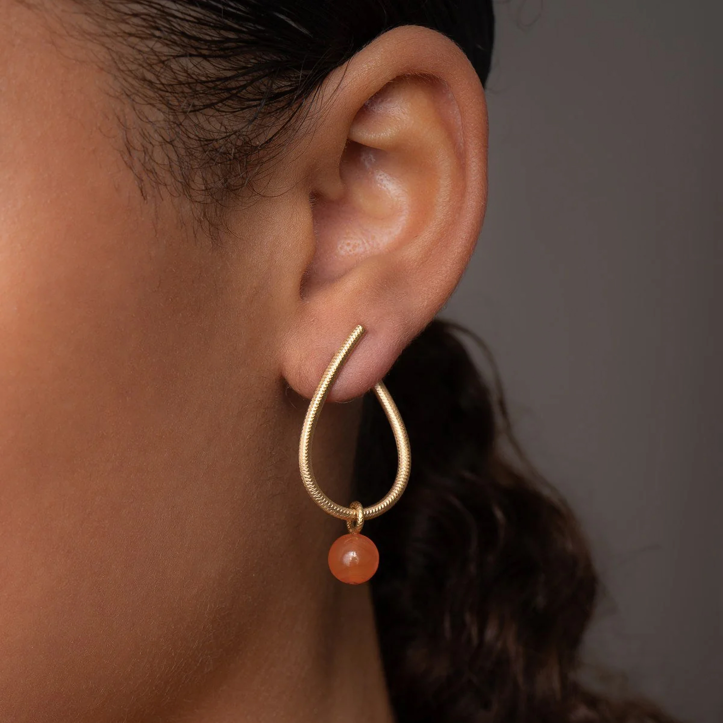 Dulong Globe örhängespåhänge i 18k guld med karneol på modell hos Herr & Fru Lohse